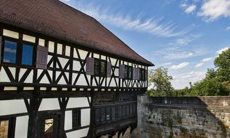 Aussenansicht der Burg Wäscherschloss mit Mauer und Fachwerk